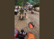Seorang Pengendara Motor Melintasi Jalan Becek di Kawasan IKN